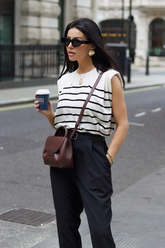 a lady wears a striped tank top with black suit pants